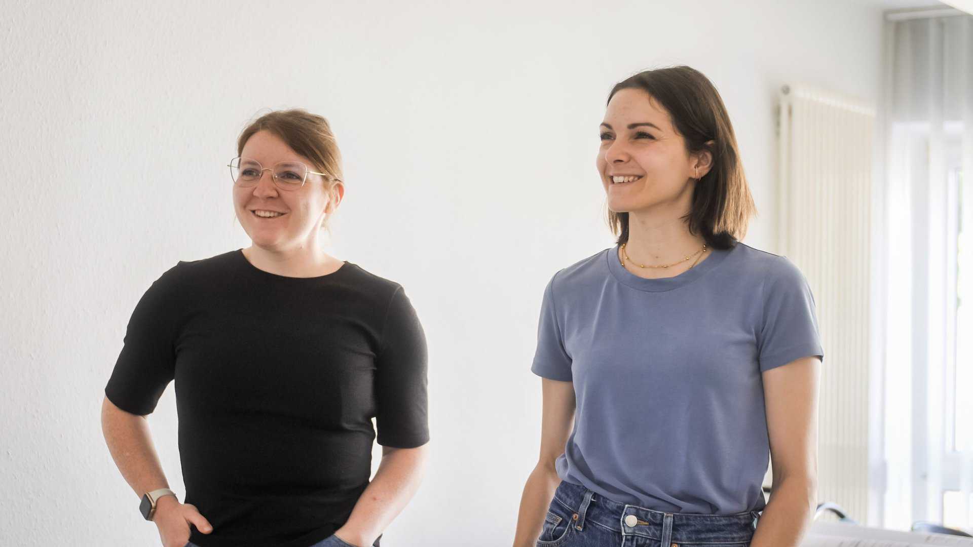 Zwei Mitarbeiterinnen vom Ingenieurbüro IBOS lächeln